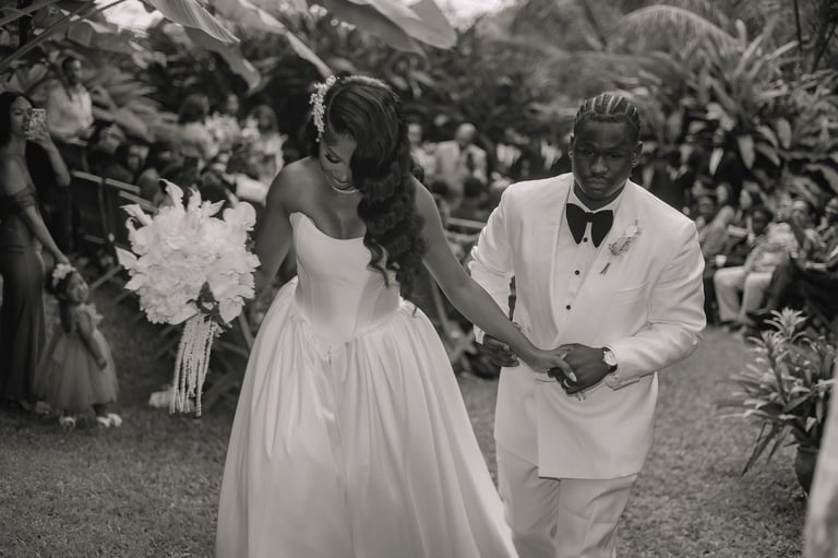 Bride and groom walking together in a garden ceremony, black and white wedding photograph